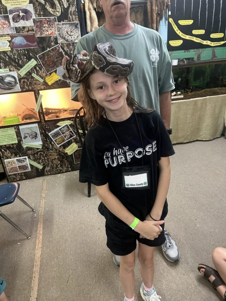 Girl with a snake on her head.