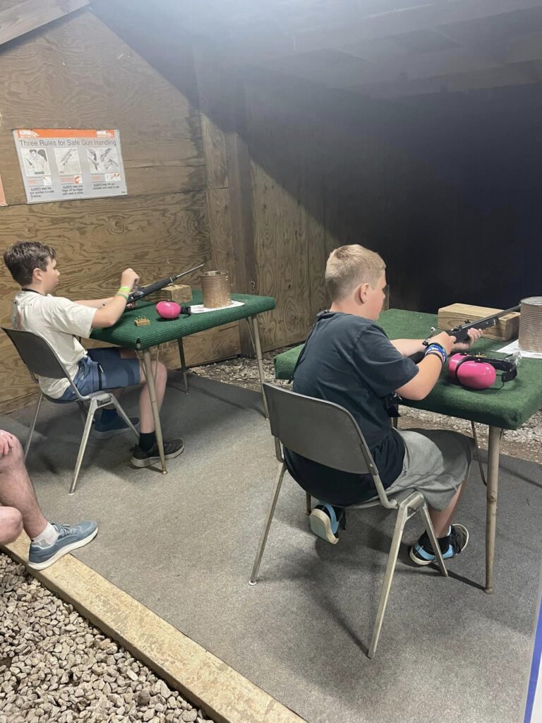 Kids sitting at rifle range.