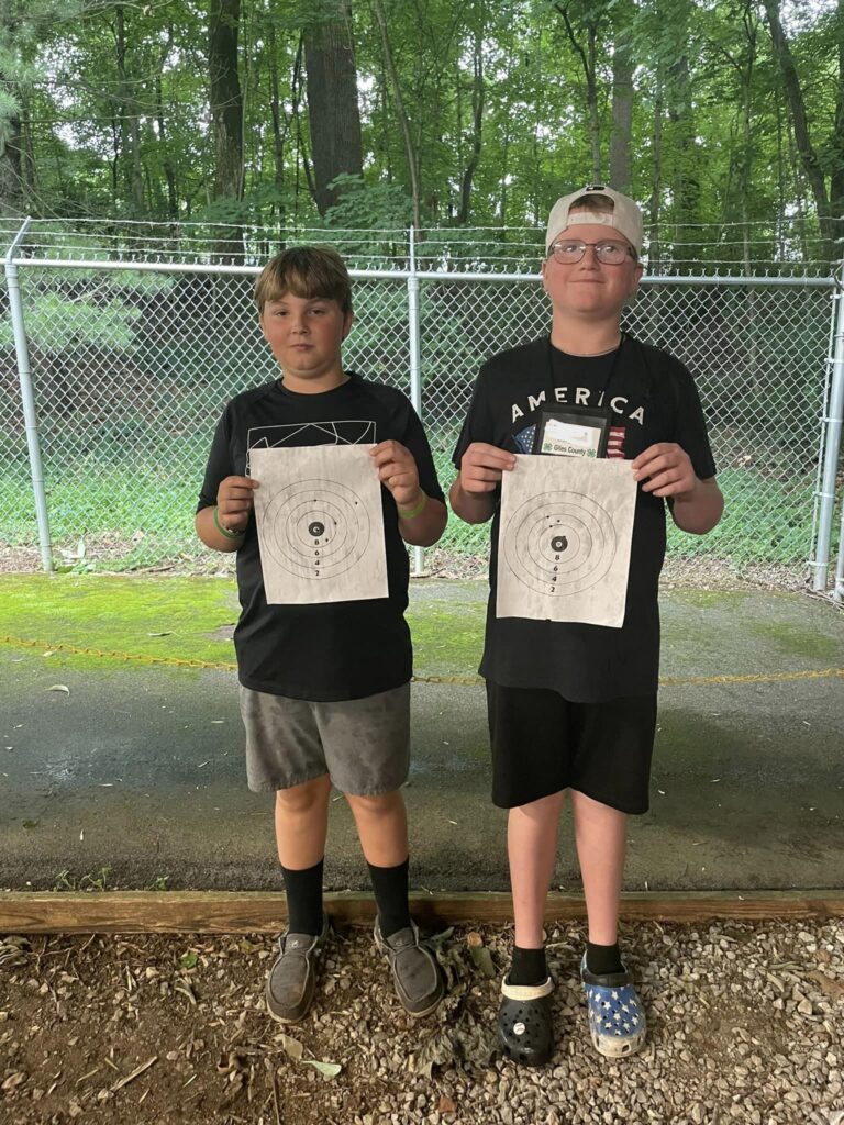 Kids displaying targets from rifle range.