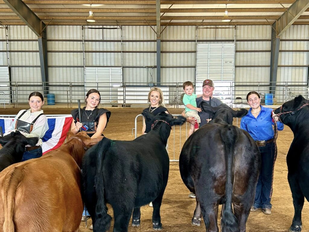 4-H'er and 4-H Agent standing with cows.