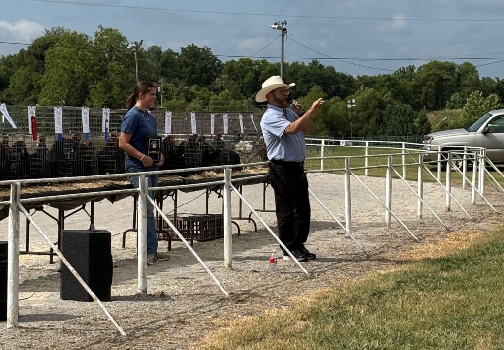 4-H poultry show auctioneer with 4-H'er and chickens.